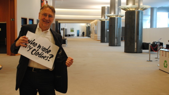 Bernd Lange hält ein Schild hoch, auf dem steht: "Who made my clothes?"
